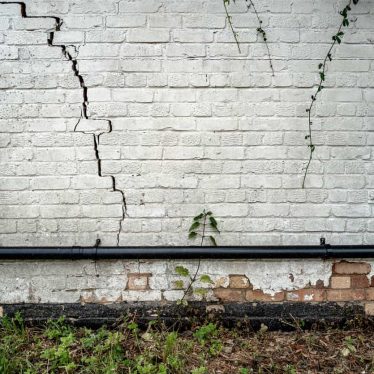 A commercial building’s wall with cracks from freeze-thaw damage.